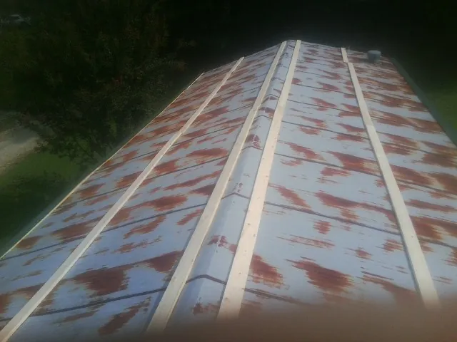 Rusted metal roof panels with new wood purlins before replacement — Storm Damage Roof Repair in Goldston by Roofing Brothers